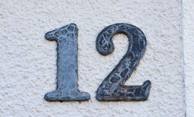 Beyaz bir duvara kazınmış 12 numara.