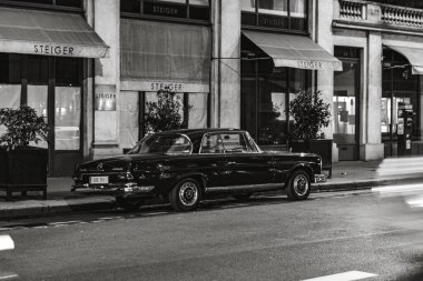 Mercedes Benz W111 'in gri tonlu resmi. Paris, Fransa' da sokağa park edilmiş klasik lüks araba.