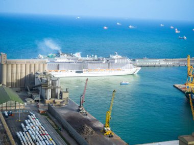Kargoları, vinçleri ve depoları olan bir geminin havadan görüntüsü.