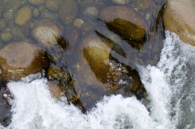 Gün boyunca bir dağ nehrinde akan suyun yakın çekim görüntüsü.