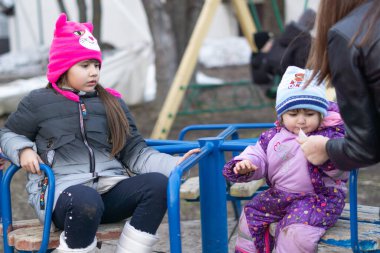 Anne ve kızları bir lunaparkta oynuyorlar.
