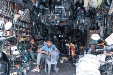 Phnom Penh, Kamboçya 'da müşterileri bekleyen kullanılmış elektrikçi dükkanındaki tedarikçi erkeklerin güzel bir fotoğrafı.