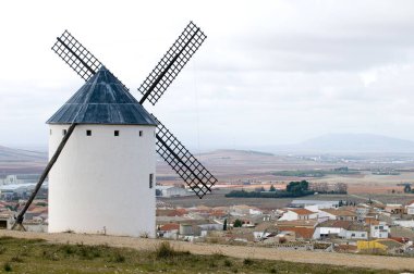 Şehrin arka planına karşı dev beyaz bir İspanyol yel değirmeni