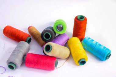 Beyaz arkaplanda canlı renkli iplikler