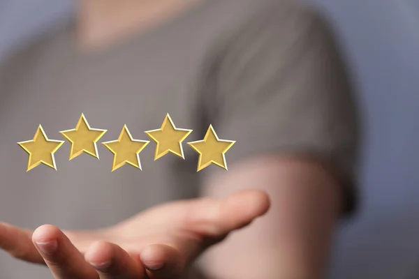 An illustration of a five star rating in yellow floating above the hand