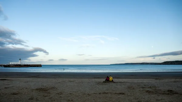 坐在沙滩上的特写镜头 背景是大海 — 图库照片