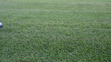 Profesyonel bir golf sahasında golf topu atan bir erkek golfçü.