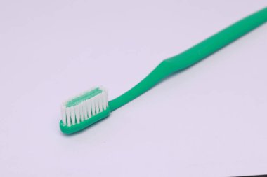 Beyaz arkaplanda izole edilmiş yeşil bir diş fırçasının yakın çekimi.