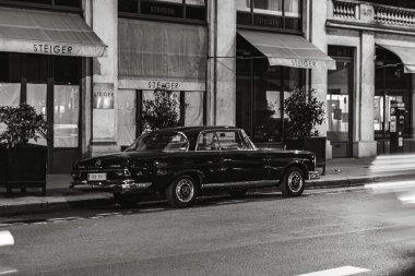 Mercedes Benz W111 'in gri tonlu resmi. Paris, Fransa' da sokağa park edilmiş klasik lüks araba.
