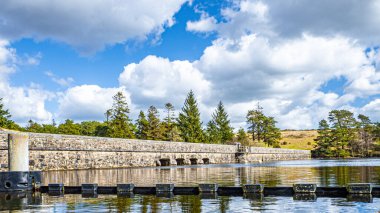 Nehrin üzerinde taş bir köprünün fotoğrafı.