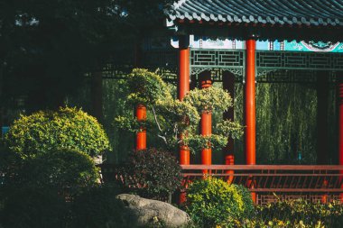 Bitkilerle dolu bir bahçedeki Çin pavyonlarının güzel manzarası.