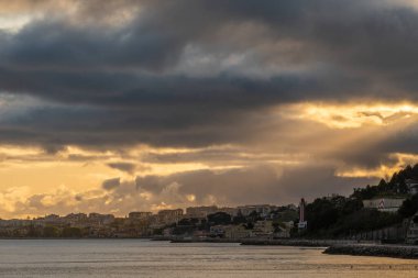 Lizbon, Portekiz 'de Cruz Quebrada plajında gün batımının manzarası bulutlu arka planda.