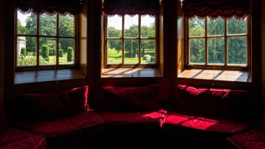 Kırmızı kadife pencere oturağı ve eski pencereler