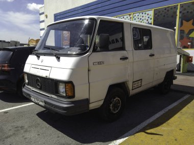 Caddeye park etmiş eski beyaz minibüs, klasik Mercedes Benz MB140.