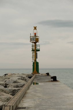 Kasvetli bir günde dalgalı suda metal bir kule