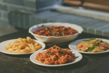 Beyaz tabakta dört farklı tabağın yakın plan fotoğrafı.