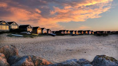 Mudeford Quey, Christchurch, Bournemouth, İngiltere 'deki sahil kulübeleriyle büyüleyici gün doğumu.