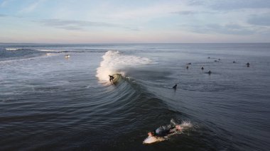 Dalgalar ve sörfçülerle dolu güzel bir deniz manzarası