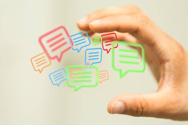 3D uçan baloncuklara dokunan bir erkek eli beyaz arka planda parmaklarıyla ikonları sohbet ettirir.