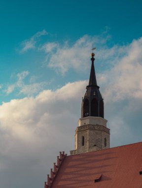 Almanya 'da Helmsdorf' ta mavi gökyüzünde beyaz bulutlarla kilisenin dikey görüntüsü.