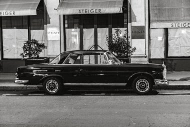 Mercedes Benz W111 'in gri tonlu resmi. Paris, Fransa' da sokağa park edilmiş klasik lüks araba.