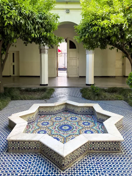 Empty mosaic courtyard with a small fountain in the middle