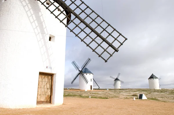 Arka plandaki dev bir İspanyol yel değirmeninin ve diğer yel değirmenlerinin yakın çekimi.