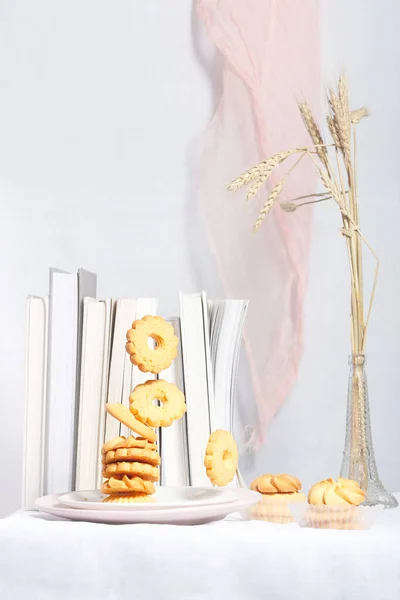 Colpo Verticale Biscotti Piatto Bianco Con Libri Grano Sullo Sfondo — Foto Stock