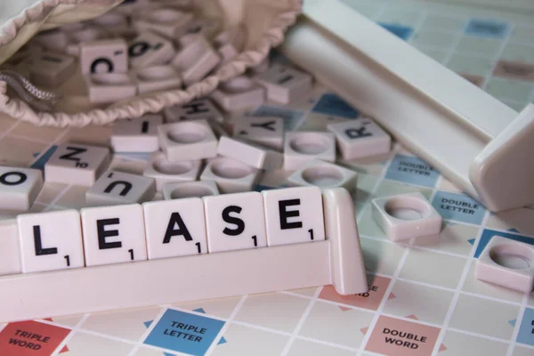 Closeup White Cubes Spelling Word Lease Board Game — Stock Photo, Image