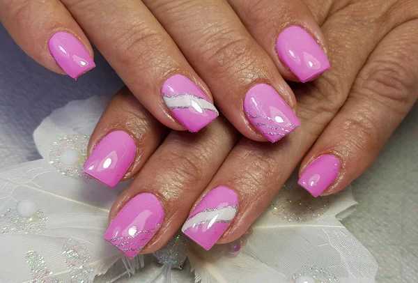 a close-up with gel-painted nails - pink colour