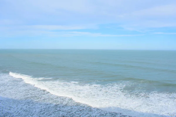 晴れた日に青い空の下で砂浜をクラッシュ波の海の美しいショット — ストック写真