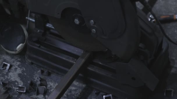 金属製の切断機によって鉄の四角形のチューブを切断し 製造工場で火花を発生させるビデオ — ストック動画
