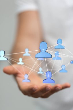 Bir elin üzerinde süzülen nöral ağlarla bağlantılı mavi renkli insan figürlerinin dikey 3D görüntüsü