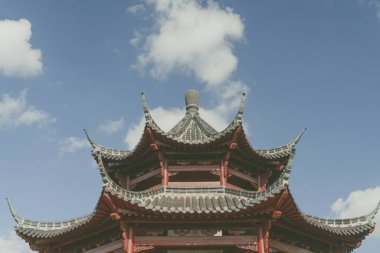 Mavi bulutlu gökyüzüne karşı Asyalı bir binanın tepesi