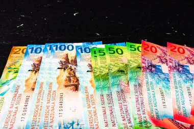 Siyah arka planda İsviçre frangı banknotları.
