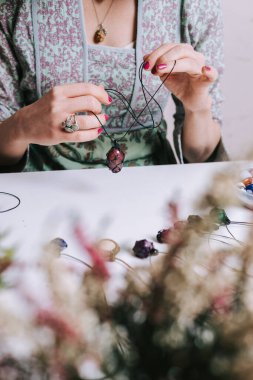 Kadın eli, el yapımı mücevher, ev yapımı atölye. Kadın esnaf mücevher üretir. Sanat, hobi, el işi konsepti