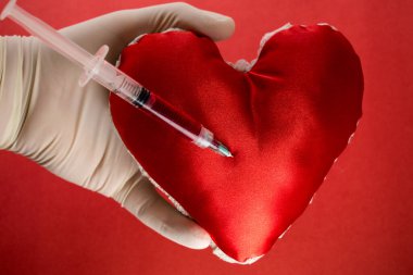 Bir şırınga ve bir kalp kan bağışı konseptini temsil ediyor.