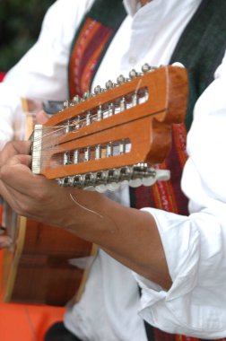Açık havada gitar çalan birinin dikey yakın çekimi.