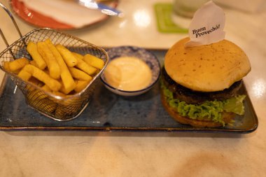 Patates kızartması, sos ve hamburger tabakta afiyet olsun.