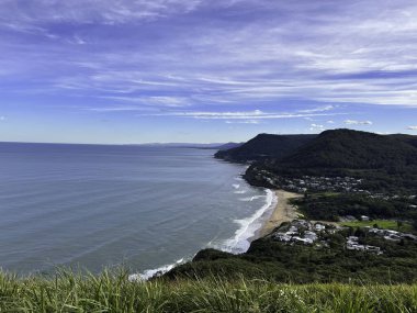 New South Wales, Avustralya 'daki Bald Hill Gözcüsü' nden Stanwell Park 'ın kıyı şeridinin mavi gökyüzü arka planında manzarası.