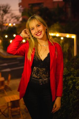 Parkta fotoğraf çektirmek için poz veren güzel bir kadın.