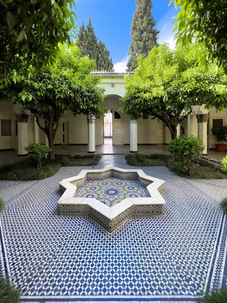 Empty mosaic courtyard with a small fountain in the middle