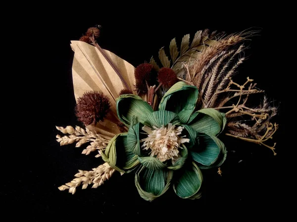 黒を背景に藁や布で作られた偽の花 — ストック写真