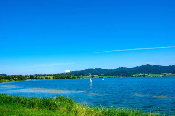 小さなボートが水の中で泳いでいる青い湖の美しい景色スイス — ストック写真