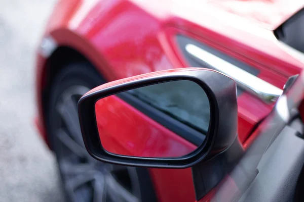 停在街上的一辆红色跑车的镜子的特写 — 图库照片