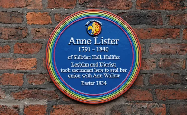 A sign of Commemorative blue plaque with rainbow edging for Anne Lister, lesbian and diarist on a wall in York, UK