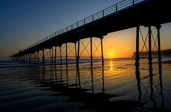 夕日の海に架かる橋のシルエット — ストック写真