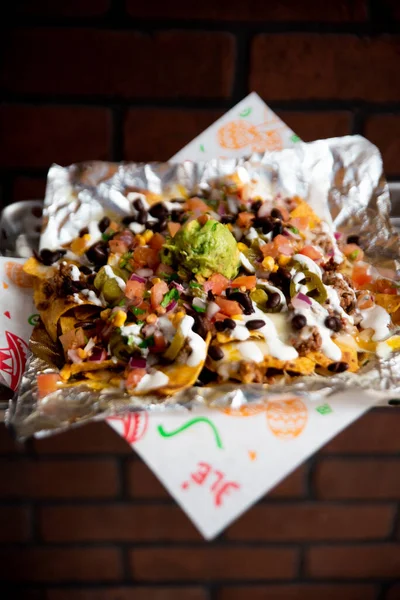 Vertical Shot Mexican Nachos Sour Cream Guacamole Tomato Sauce Foil — Stock Photo, Image