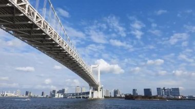 Tokyo Körfezi ve Gökkuşağı Köprüsü 'nün çağdaş binaların ufuk çizgisi ile hızlandırılmış görüntüleri.