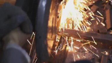 Fabrikada kıvılcım çıkaran bir metal kesme makinesi.